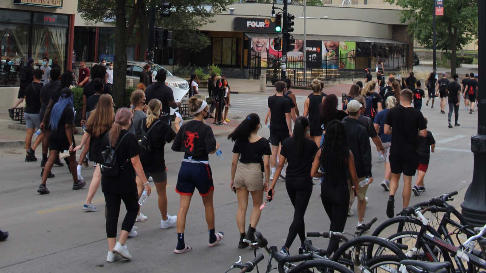 University of Illinois athletes, fellow students and community members march north on First Street through Campustown