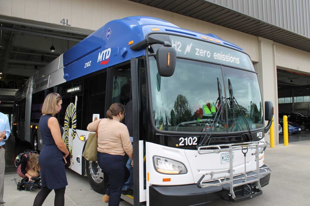 Two women board a blue, low-floor bus at the Champaign-Urbana Mass Transit District headquarters.