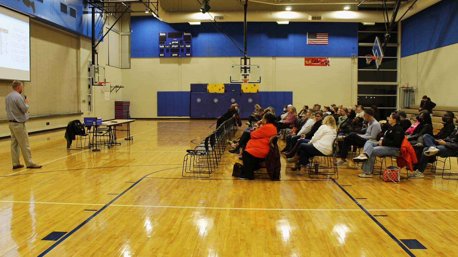 Black and white parents and grandparents sit in the gym at Garden Hills Elementary.